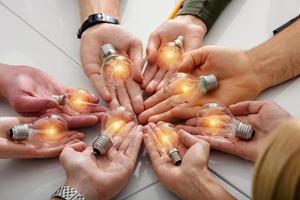 Teamwork and brainstorming concept with businessmen that share an idea with a lamp photo