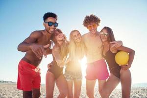 Group of friends playing at beach volley at the beach photo