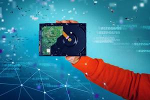 Man holds an hard disk. concept of storage and memory. cyan background photo