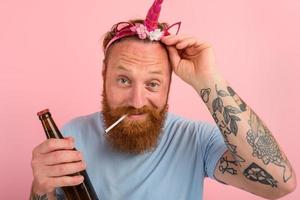 Happy man with beard and tattoos acts like a princess of a tale photo