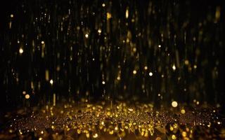 gold particle bokeh on black background photo