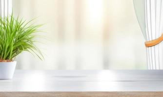 wooden table top on blurred background of half curtained window photo