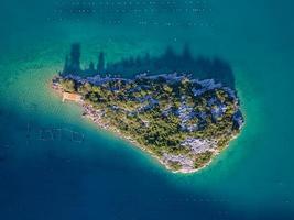 Aerial drone view of a small island in the bay of Mali Ston located on Peljesac peninsula. Oyster farms in the turquoise sea water. Unique mix of freshwater and seawater. photo