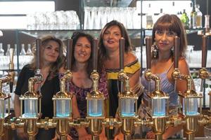 group of mature women is drinking beer in a pub in front of a beer tap photo