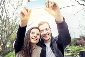 nice couple boyfriends takes a selfie relaxing in the park outdoor photo