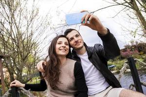 nice couple boyfriends in the park takes a selfie photo