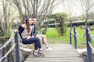 bonito Pareja de novios abraza y Besos en un de madera puente foto