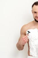 Young man shaving his chest photo