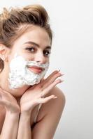 Woman with shaving foam on her face photo