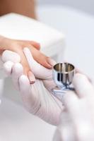 Woman receiving manicure by airbrush photo