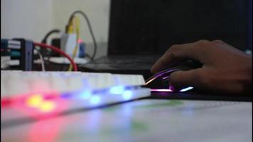Indonesian man's hand using rgb mouse on table at home. video