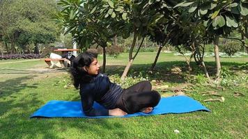 joven india practicando yoga al aire libre en un parque. hermosa chica practica pose básica de yoga. calma y relax, felicidad femenina. posturas básicas de yoga al aire libre video