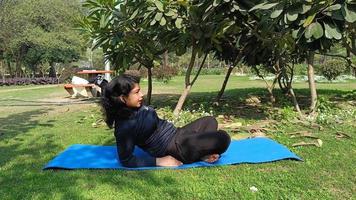 giovane indiano donna praticante yoga all'aperto nel un' parco. bellissimo ragazza pratica di base yoga posa. quiete e relax, femmina felicità. di base yoga pose all'aperto video