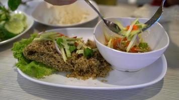 person eating crispy catfish with Mango salad,Thai food video