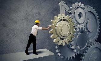 Businessman turning a gear system photo