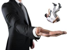 Businessman is saved from a big hand. Concept of business support and assistance photo