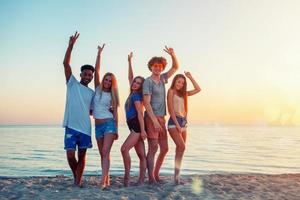 Group of friends having fun on the beach. Concept of summertime photo