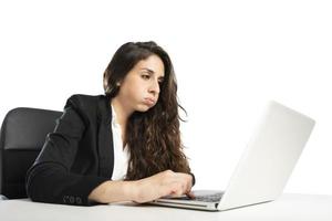 Bored woman snorts in the office while working on the laptop photo