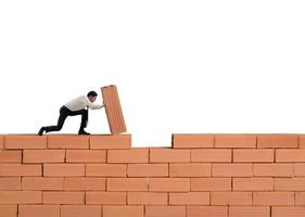 Businessman puts a brick to build a wall. Concept of new business, partnership, integration and startup photo