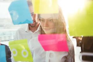 Business people that work together in office to a new project with post-it. Concept of teamwork, partnership and startup photo