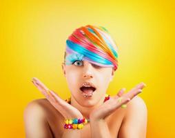 Girl with rainbow colorful fashion makeup on yellow background photo