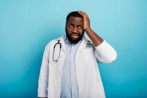 Scared doctor face expression due to coronavirus pandemic. Blue background photo