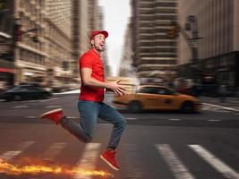 Messenger in red uniform runs on foot really fast to deliver quickly hot pizzas just baked photo