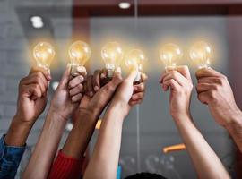 Teamwork and brainstorming concept with businessmen that share an idea with a lamp. Concept of startup photo