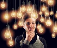 Young smart boy illuminated by light bulbs. Concept of creativity idea photo