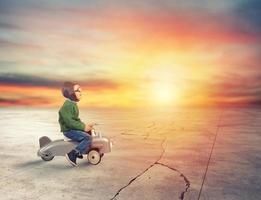 Kid plays with a small airplane during sunset photo