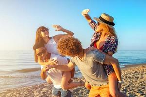 Happy smiling couples playing at the beach photo