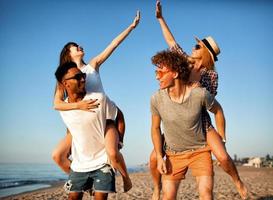 Happy smiling couples playing at the beach photo