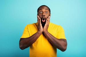 Amazed and shocked expression of a boy over cyan background photo