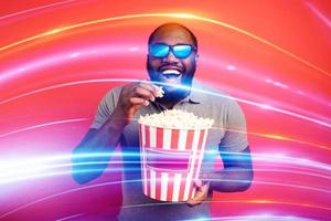 Boy has fun watching a film. Concept of entertainment and streaming tv. red background photo