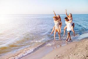 Happy smiling couples playing at the beach photo