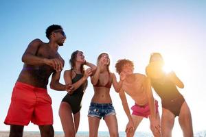 Group of friends playing at beach volley at the beach photo