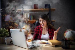 Stressed and angry woman with explosed computer due to overwork photo