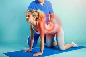 Girl performs exercises with a physiotherapist. Cyan background photo