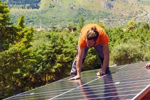 Workers assemble energy system with solar panel for electricity photo