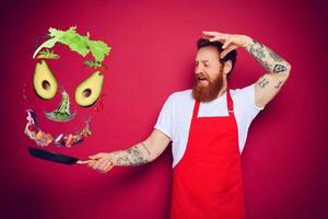 Man chef with pan in hand acts like a sorcerer photo