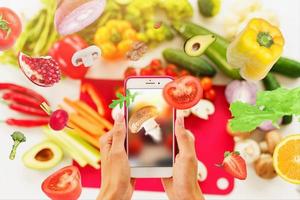 cocinar sigue un receta de vegetales desde el teléfono inteligente foto
