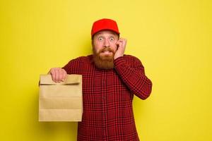 Delivery man with hat and beard has an afraid expression photo