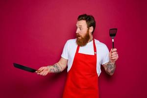 wondered chef with beard and red apron is ready to cook photo