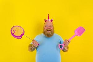 fat man with headband play with sea net and paddle photo