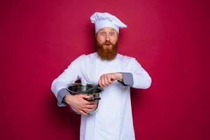 Happy chef with beard and red apron is ready to cook photo