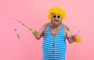 Fat happy man with beard and sunglasses have fun with the fishing pole photo