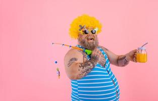 Fat happy man with beard and sunglasses have fun with the fishing pole photo