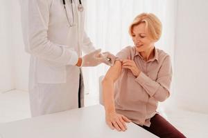 Doctor with mask and syringe is ready to administer the vaccine against covid 19 photo