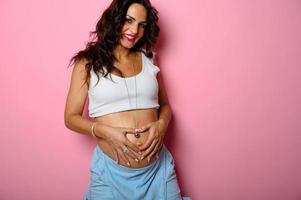 Pregnant happy woman expecting a child caresses her belly photo