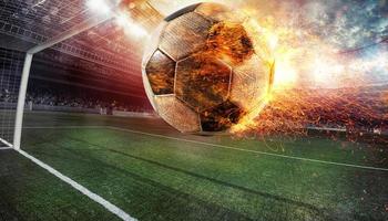 cerca arriba de un ardiente fútbol pelota golpeado con poder a el estadio puntuación un objetivo foto